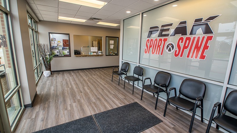 interior view of waiting room for physical therapy clinic with Peak Sport and Spine logo on wall