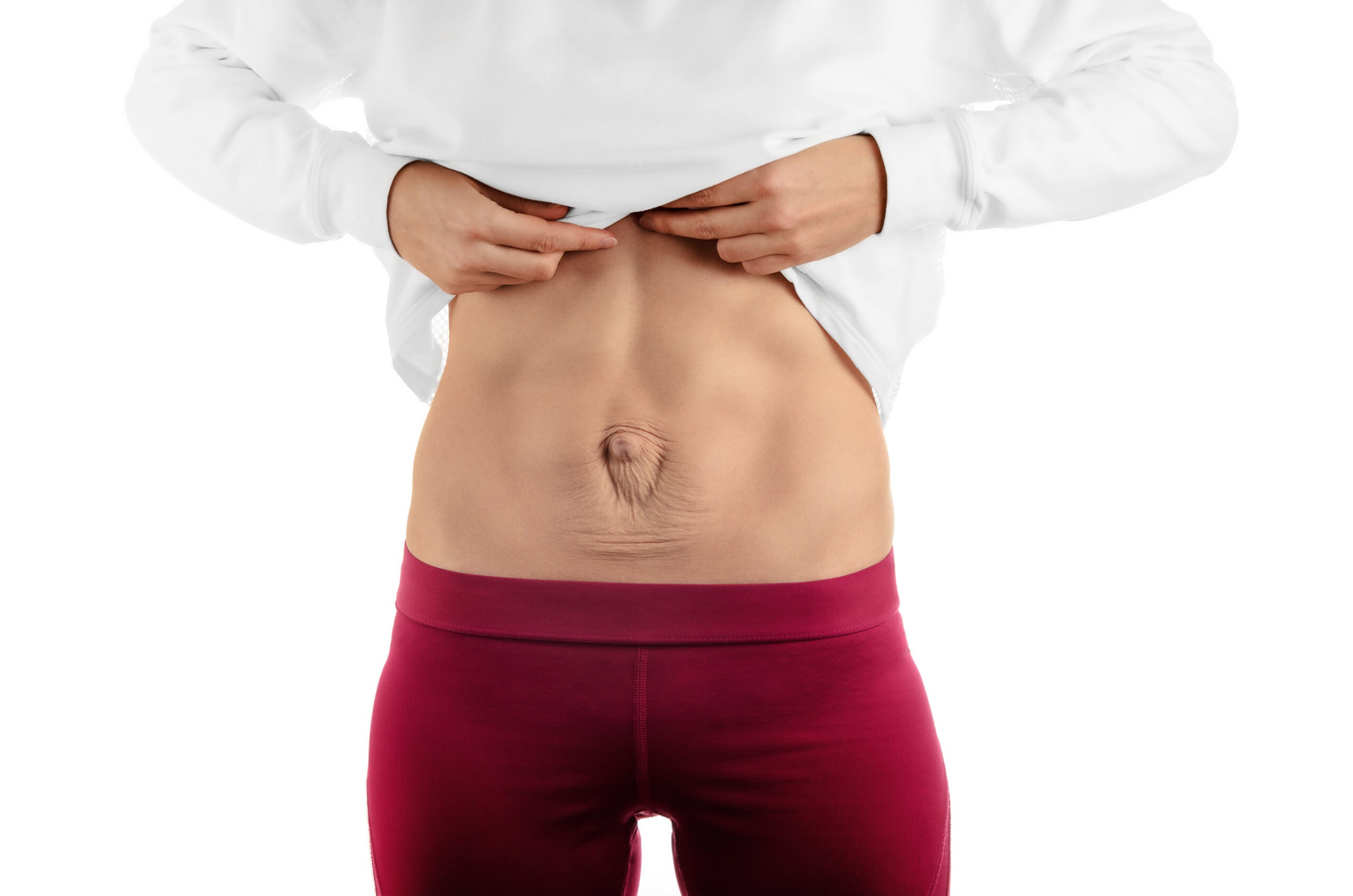 woman with diastasis recti lifting up her shirt to show how to tell if you have diastasis recti